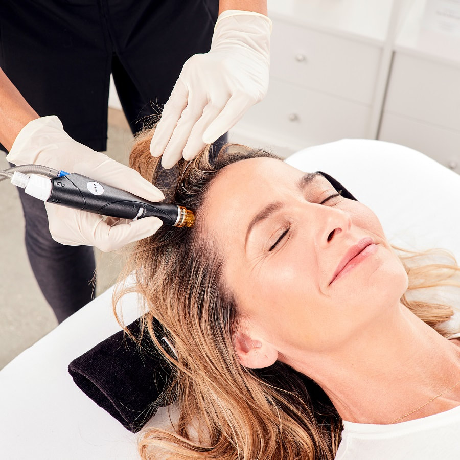 woman closing eyes and smiling while receiving Keravive treatment for scalp